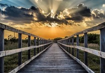 A wooden boardwalk trail at sunset.