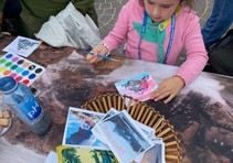 A child coloring a picture on a table.