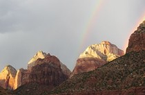 A rainbow over a rock mountain range.