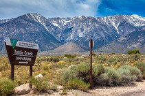 A mountain range with a sign in front that reads Tuttle Creek campground.