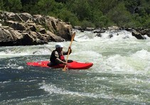 A kayaker in a red kayak.