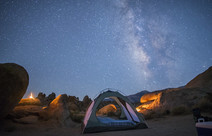 A tent at night under a starry sky.