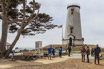 People standing around the base of a lighthouse.