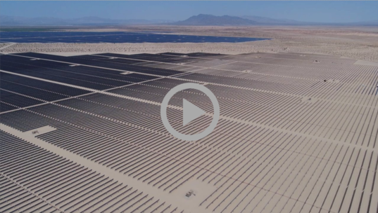 A large field of solar energy panels in the desert 