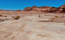 A dry road towards a desert mountain range.