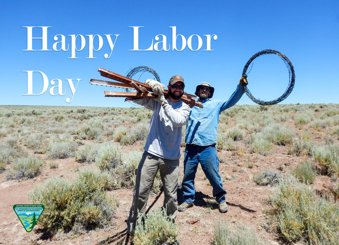 Two BLM employees holding wires with the words Happy Labor Day.