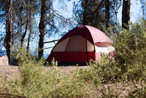 A red tent set up at a campsite.
