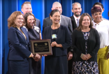 Secretary Deb Haaland holding a plaque with other people.