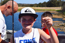 A kid holding up a fishing lure.
