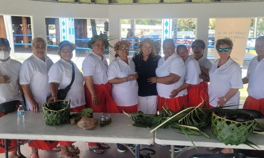 Assistant Secretary Cantor in American Samoa standing alongside women in front of a white table