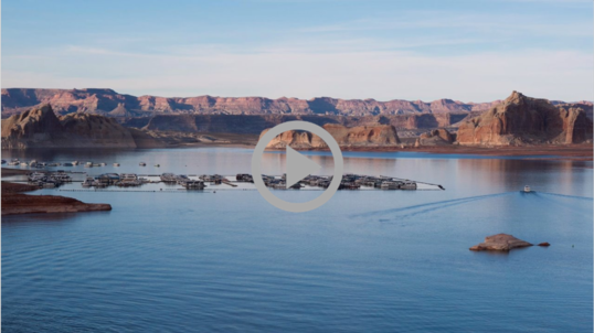 Mountainous landscape surrounds the waters of Lake Mead, boats float in the water