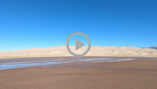 A massive sand dune under a bright blue sky at Great Sand Dunes National Park 