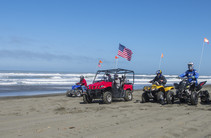 OHV riders on a beach.