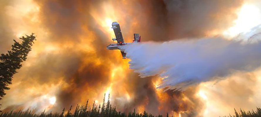 A plane seen from below dropping water on the Clear Fire in Fairbanks, Alaska. Photo by Eric Kiehn, Kittitas County Fire District 1.