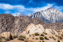 Iconic Alabama Hills with snow covered mountains and rock features. 
