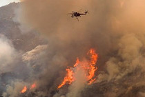 Wildfire with fire helicopter overhead