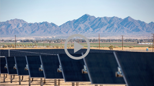 Solar panels in the foreground with mountains in the background