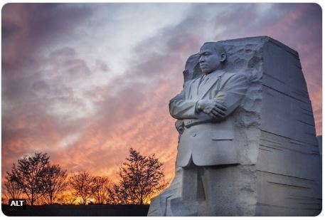 The Stone of Hope statue shows a figure of Dr. Martin Luther King Jr. etched into the side of a rock wall during sunset. 
