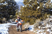 Motorcyclist riding in a snowy trail 