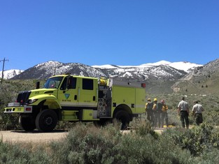 BLM fire truck with firefighters standing around 