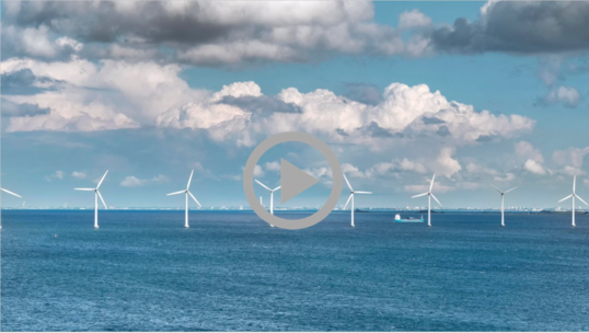 Ocean wind turbines spin under a cloudy ocean sky