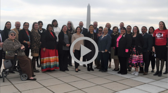 Secretary Haaland poses on the Interior roof with members of the Not Invisible Act Commission. The Washington Monument is visible in the background.