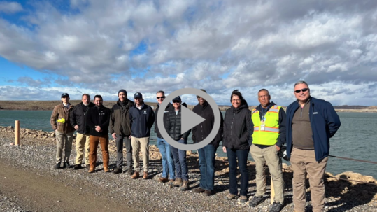 A group photo in from of a reservoir at the Navajo-Gallup Water Supply Project.