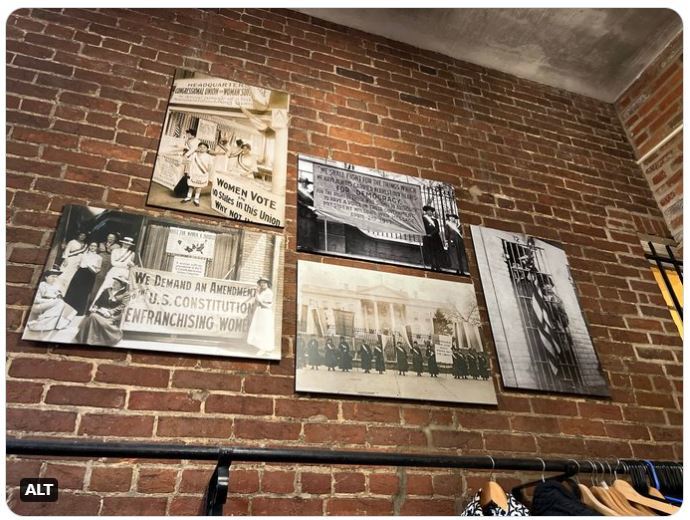 Series of historic photos from the women's suffrage movement posted on a brick wall.