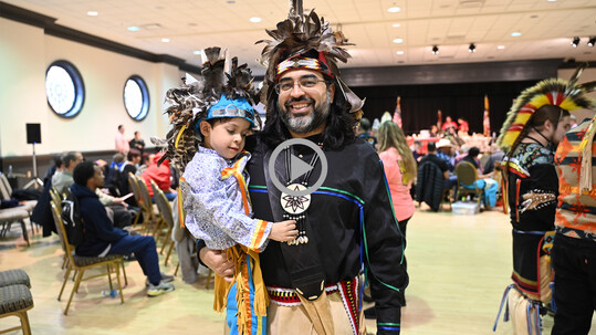 A native artist holding a child.