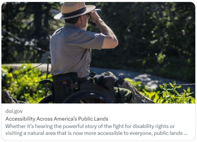 A park ranger sitting in a wheelchair looking through binoculars. This photo is linked to the DOI Accessibility Across America’s Public Lands blog.