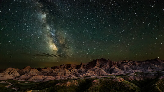 Bright stars shine in a dark sky over Badlands National Park in South Dakota.