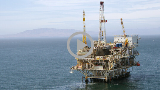 An offshore oil and gas well is anchored in the ocean.
