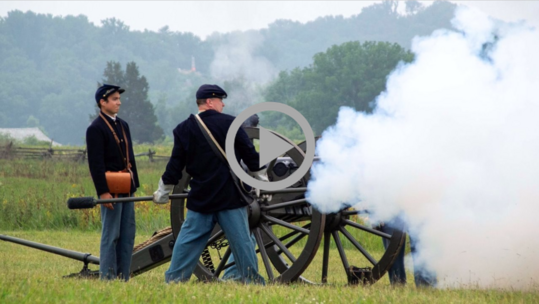 Reenactors dressed as Union troops fire a cannon at Gettysburg National Military Park. 