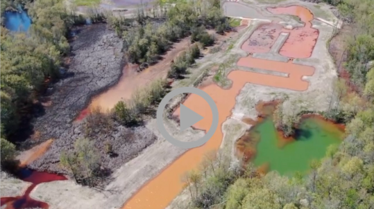 Coal mine residue and run off paint a landscape in bright colors of red, orange, and green.