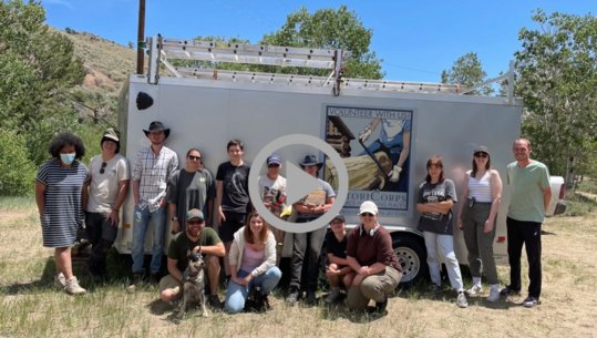 A group of landscape volunteers poses next to a trailer. 