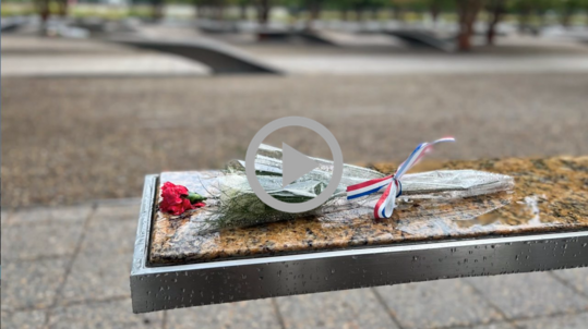 A single rose and a red, white and blue ribbon lay on a memorial bench at the Pentagon 9/11 Memorial