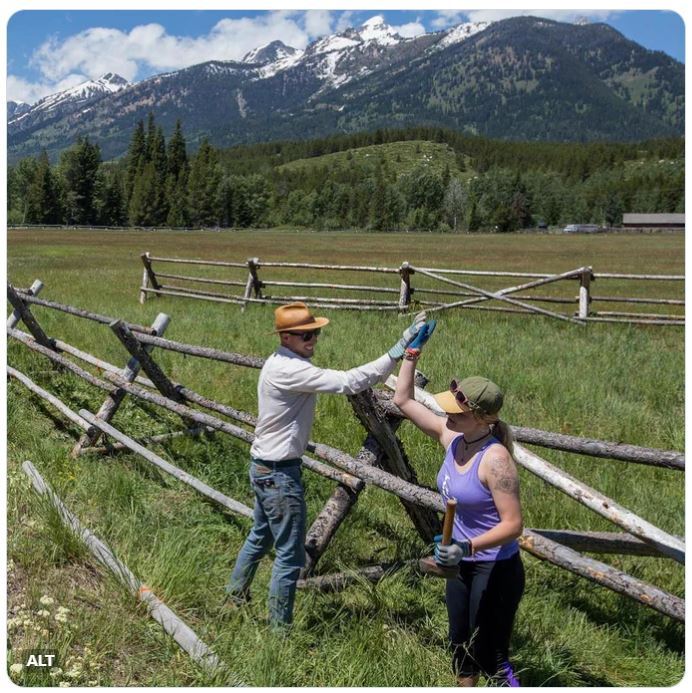 Two volunteers high five after repairing a fence at Grand Teton National Park. 