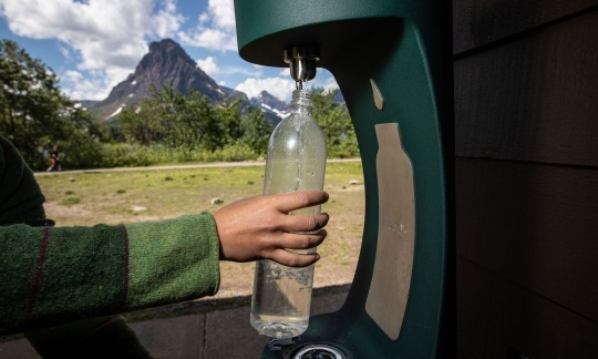 Image of someone filling up a plastic water bottle 