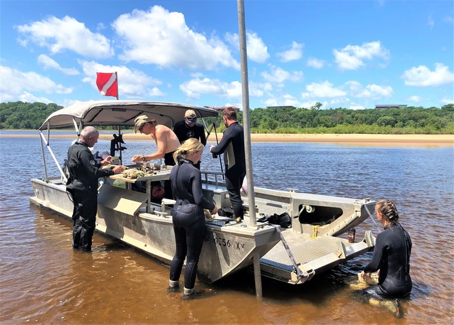 crew of FWS staff working with mussels on a boat