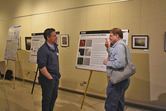 Two men conversing at the JACIE poster session