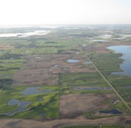 Aerial view of agricultural land with some wetlands dotting the landscape