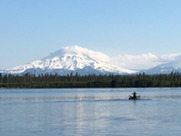 Boat on lake with snow-covered peak in distance