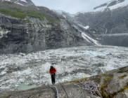 Person rappels into basin filled with water and ice