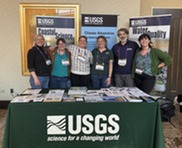 6 people stand behind USGS booth