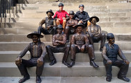 ERCA_Lockport: A man has his photo taken with bronze statues of lock tenders