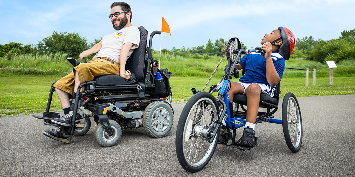 ERCA_Cedar Bay: Two young men using adaptive cycles on a trail