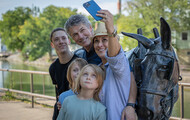 ERCA_FAIRPORT: A family takes a selfie with a mule statue on the Erie Canal