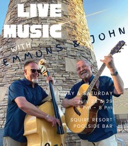 two smiling men playing acoustic instruments in front of a stone tower