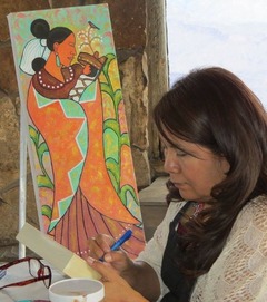 a woman mixes paint with a painted canvas behind her