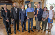 Officials hold a commemorative plaque at a ceremony honoring the Champlain Canal.